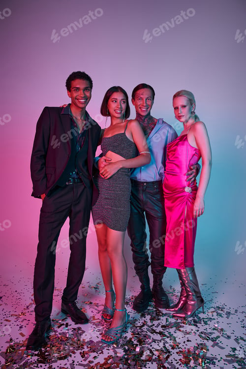 Preview: cheerful multiethnic men in festive attire and women in dresses celebrating Christmas on purple pink