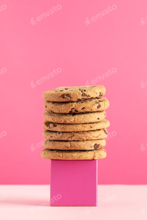 Preview: A stack of homemade cookies with chocolate chips on a pink stand on a pink background. Bakery.