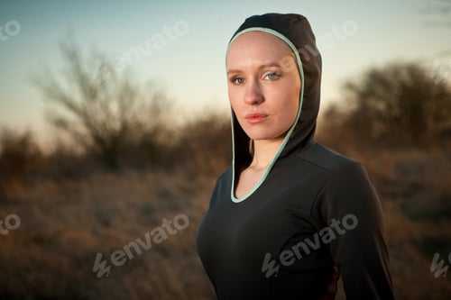 Preview: Young beautiful woman in sport sweatshirt hoody outside on the field