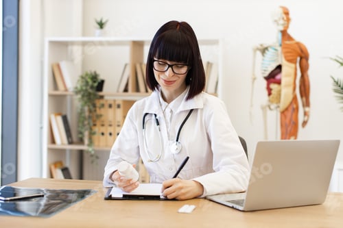 Preview: Female doctor writing prescription in medical office