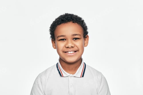 Visualização: Retrato de um lindo garoto afro-americano com um sorriso cheio de dentes. Isolado no fundo branco