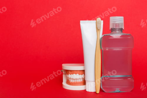 Preview: Mouthwash and other oral hygiene products on colored table top view with copy space.