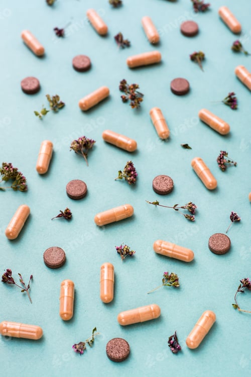 Preview: Abstract green background with capsules, pills and herbs. Alternative medicine. Vertical view