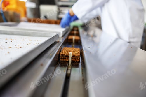 Preview: Closeup Of Worker Picking Up Biscuits Form Machine While Standing In Food Factory.
