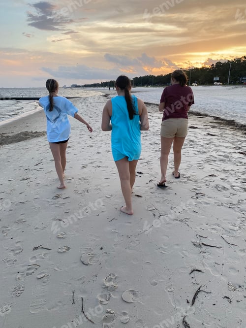 Preview: Mom and two teen daughters walking on the sandy beach