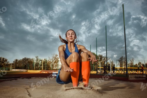 Preview: Female athlete performing a long jump during a competition