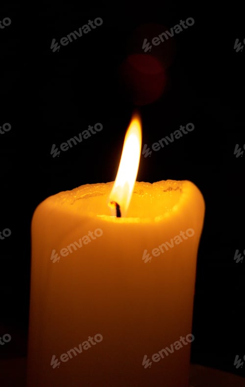 Preview: Closeup shot of a burning candle isolated on a black background