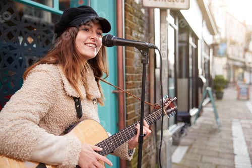 Preview: Female Musician Busking Playing Acoustic Guitar And Singing Outdoors In Street