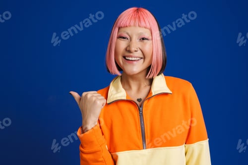 Preview: Asian girl with pink hair laughing while pointing finger aside