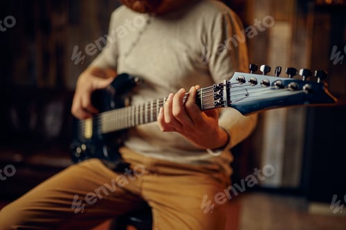 Preview: Man Playing Electric Guitar Indoors at Home