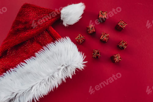 Preview: Christmas card on a red background Santa Claus hat with gifts