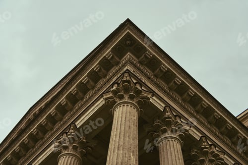 Preview: Ornate corinthian colonnade viewed from below under overcast sky