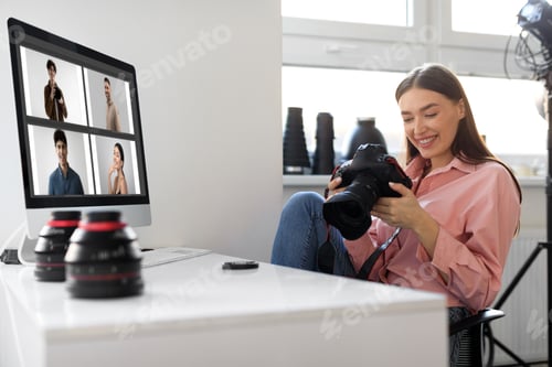 Preview: Creative young woman photographer working in studio, using computer and professional camera
