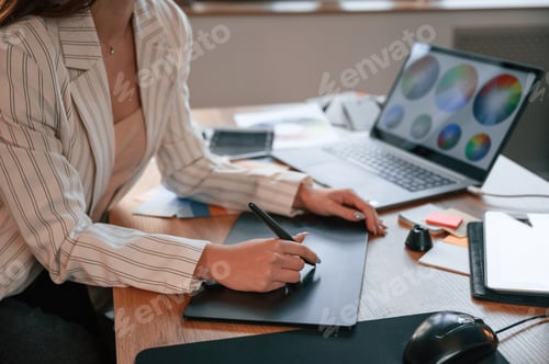 Preview: Drawing by using graphic tablet. Woman is working in the modern office with computer