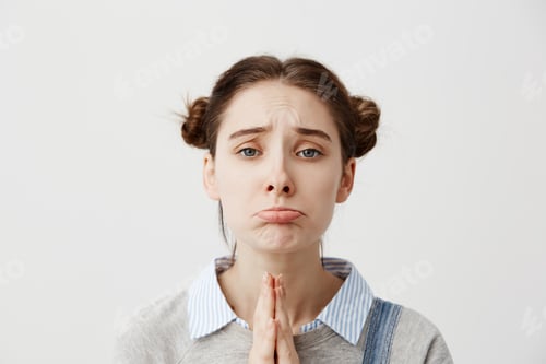 Preview: Portrait of girl 20s with upset look begging for mercy being disappointed with praying gestures