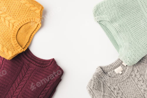 Preview: top view of cozy knitted sweaters, isolated on white