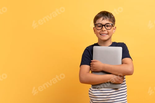 Preview: Cheerful guy school aged boy embracing computer laptop