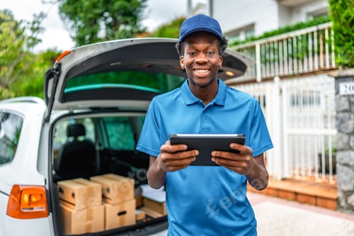 Preview: African young courier using digital tablet to deliver packages