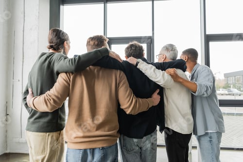 Preview: Back view of multiethnic people with alcohol addiction hugging during therapy in rehab center