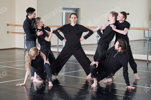 Preview: Woman with outstretched legs and group of young people exercising together