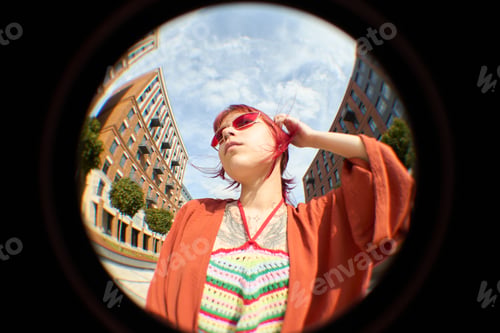 Preview: Young Caucasian Woman Standing Outdoors Wearing Sunglasses and Looking up