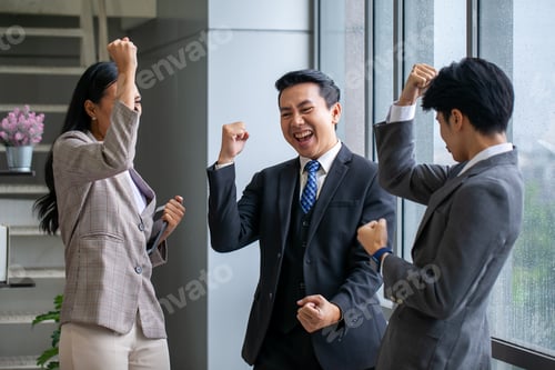 Preview: Asian business team celebrate corporate victory together in office.