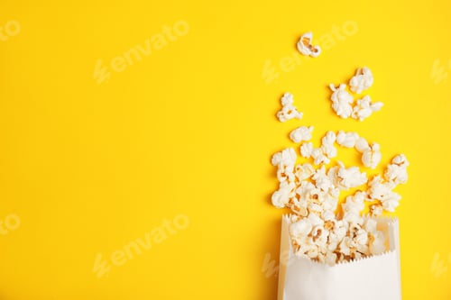 Preview: Paper bag with tasty fresh popcorn on color background, top view