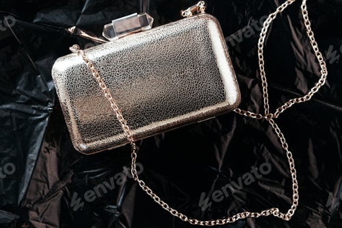 Preview: top view of stylish feminine purse on black wrapping paper background