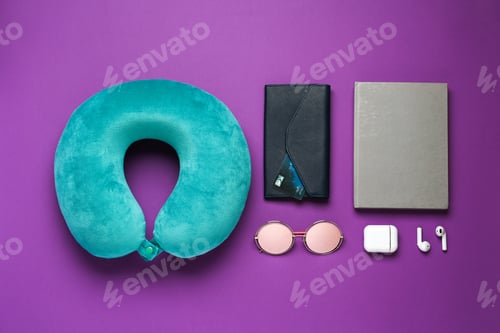 Preview: Flat lay composition with turquoise travel pillow on purple background