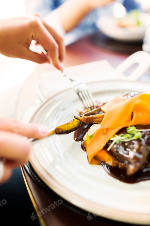 Preview: Cropped image of woman having carrot mousse in restaurant