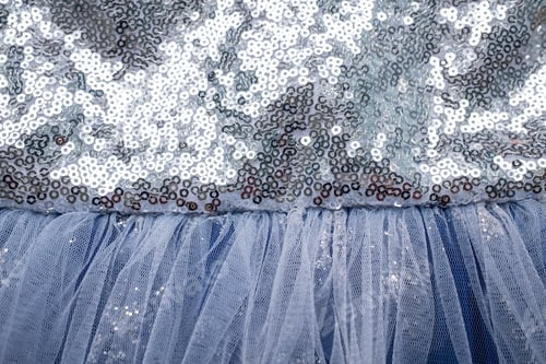 Preview: Fabric textured background, gray-blue color with sequins. Copy space. Children's beautiful dress