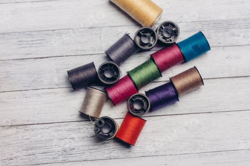 Preview: sewing accessories colored threads top view wooden background