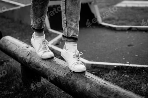 Preview: Close-up of girl's legs balancing on a log.