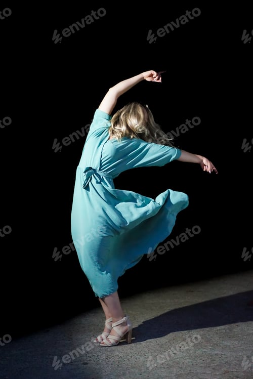 Preview: beautiful dancer in stylish dress with fringe performing tango on black background
