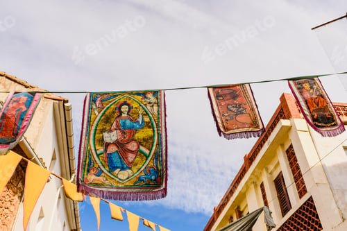 Preview: Medieval banners hanging between streets at an open-air festival.