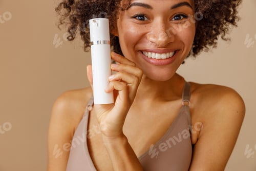 Preview: Cute female holding bottle with nourishing lotion in studio