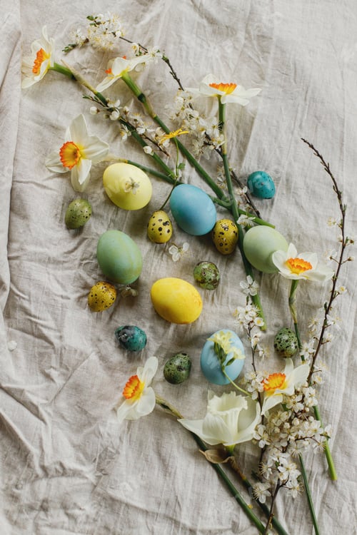 Preview: Stylish easter eggs and blooming spring flowers on rustic table flat lay. Happy Easter!