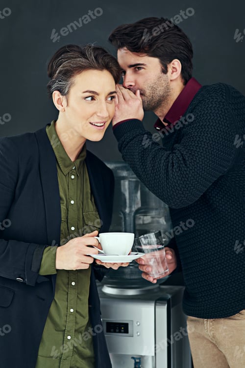 Preview: Cropped shot of two colleagues gossiping by the water cooler during a coffee break