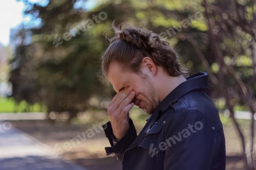 Preview: young man rubbing his eyes with his fingers