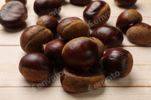 Preview: Sweet fresh edible chestnuts on light wooden table, closeup