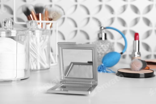 Preview: Stylish pocket mirror and cosmetic products on white table