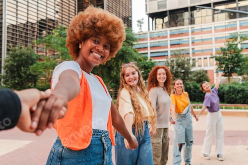 Preview: Diverse group of girls holding hands outdoors, smiling and enjoying time together in an urban park