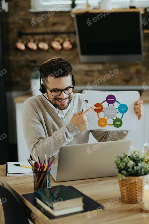 Preview: Happy entrepreneur analyzing business chart during web conference at home.
