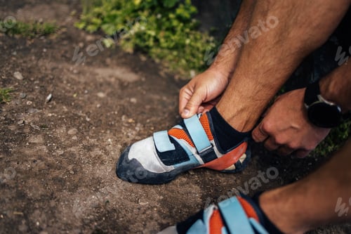 Preview: Man Securing Rock Climbing Shoes Outdoors During a Recreational Activity