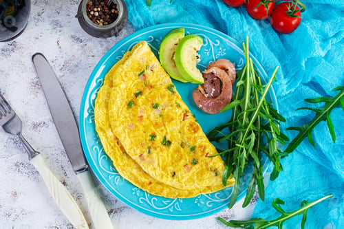 Preview: Fried omelette with ham, onion and herbs. Breakfast with scrambled eggs