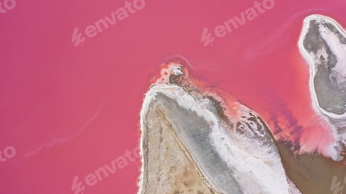 Preview: Flying over a pink salt lake. Salt production facilities saline evaporation pond fields in the salty