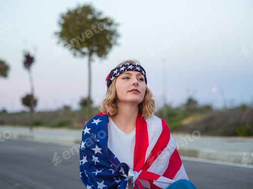 Preview: Patriotic Caucasian sitting in the middle of the road with the US flag draped around her