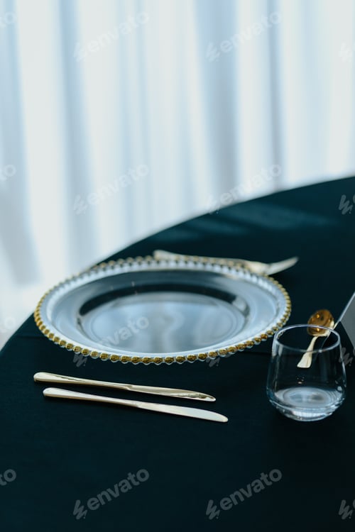 Preview: Modern table display with a glass plate surrounded by golden cutlery