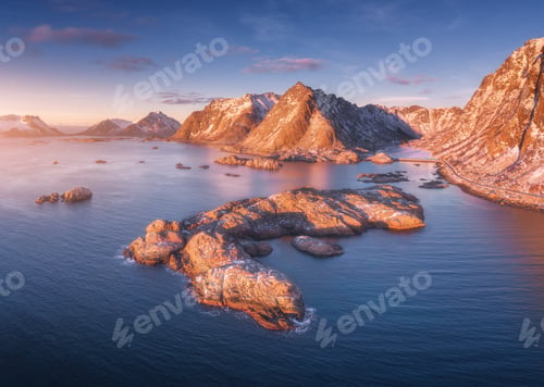 Preview: Aerial view of rocks in sea, snowy mountains, blue sky