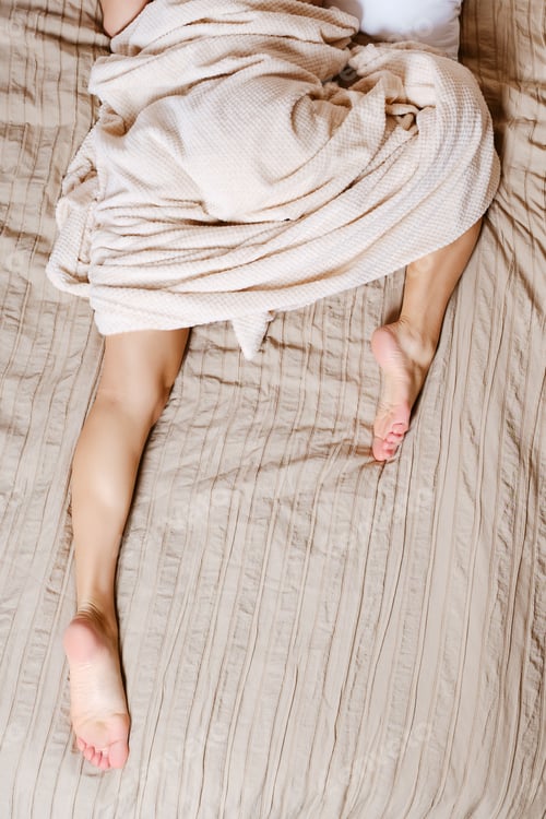 Preview: Woman sleeps lying on her stomach with one leg tucked under her